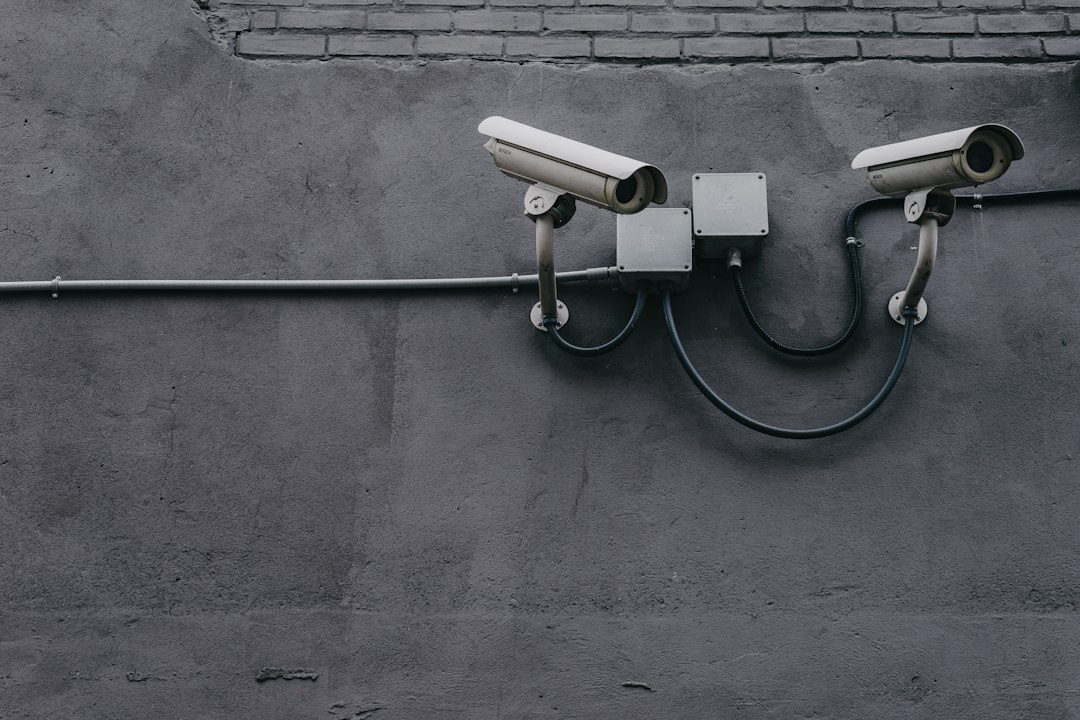 two security cameras mounted on a gray wall